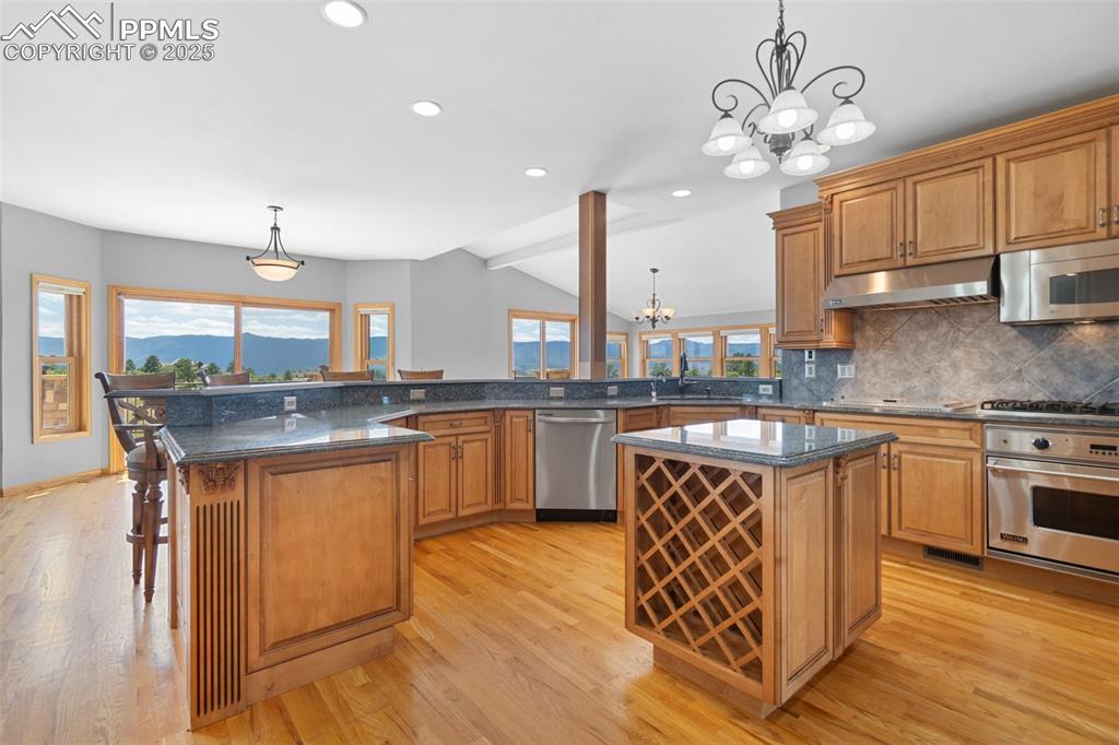 Image 10 of 50: Kitchen featuring stainless steel appliances, a chandelier, under cabinet r