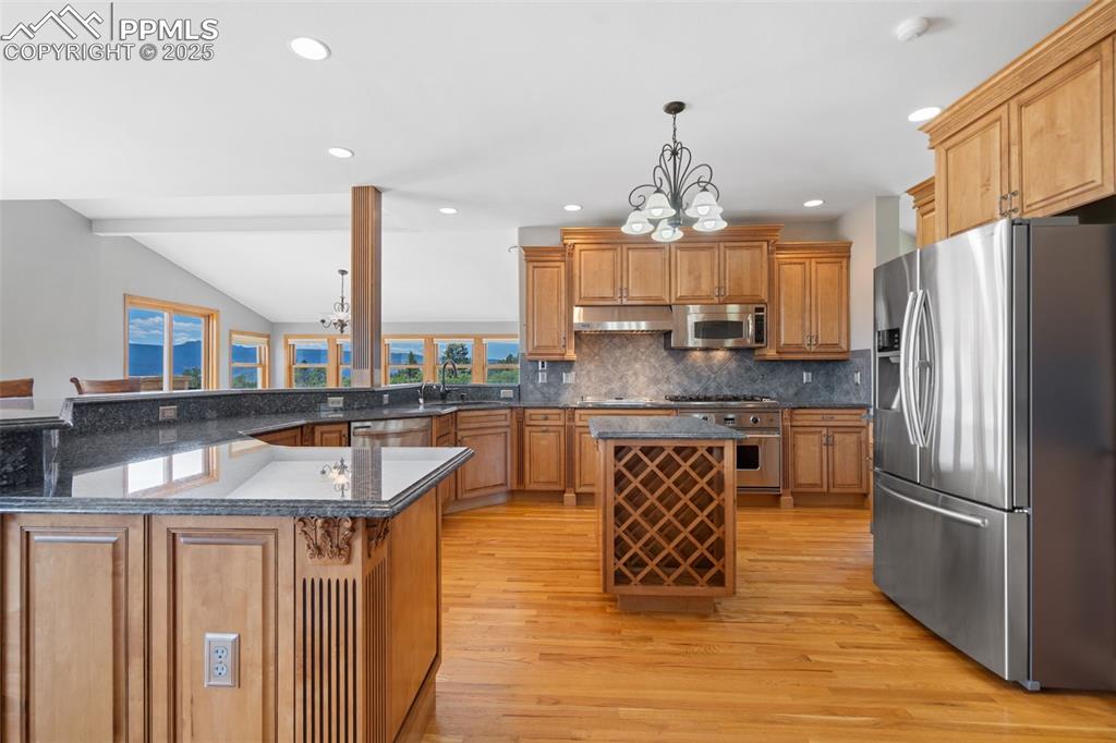 Image 11 of 50: Kitchen with stainless steel appliances, light wood-style floors, plenty of