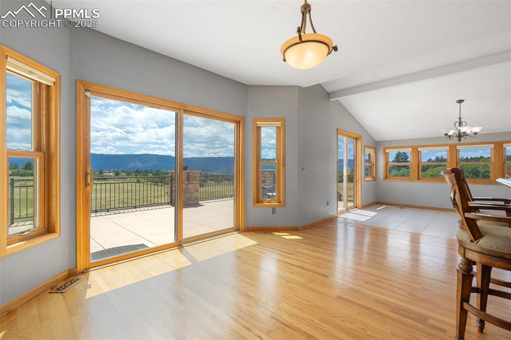 Image 13 of 50: Unfurnished dining area with a chandelier, wood finished floors, and a moun