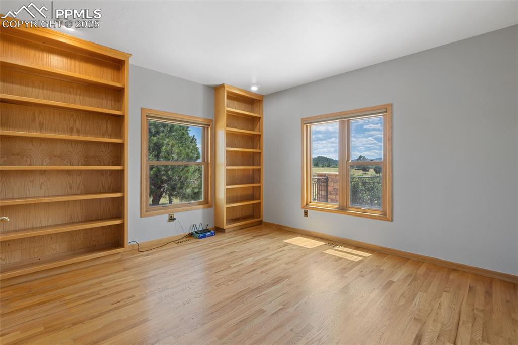 Image 19 of 50: Empty room with wood finished floors and healthy amount of natural light