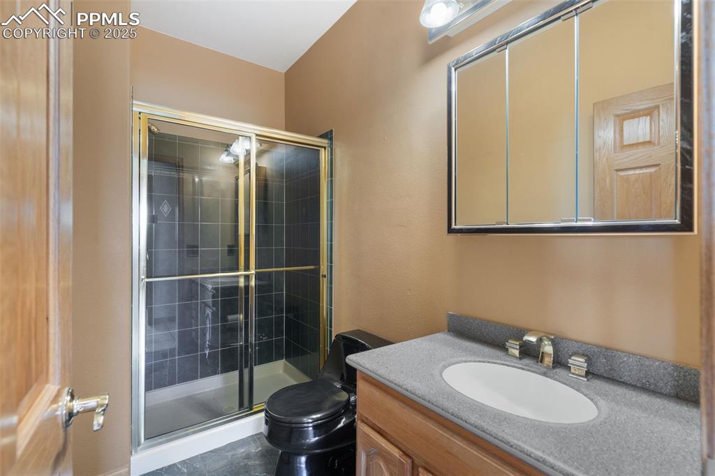 Image 20 of 50: Full bathroom featuring a stall shower and vanity