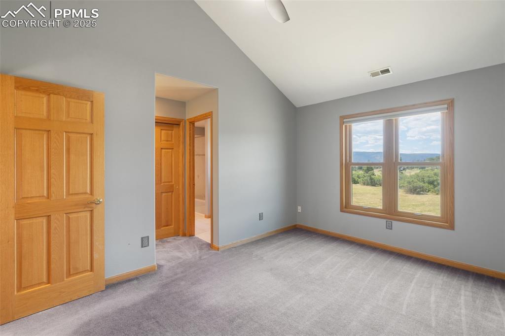 Image 24 of 50: Unfurnished room with carpet flooring and lofted ceiling