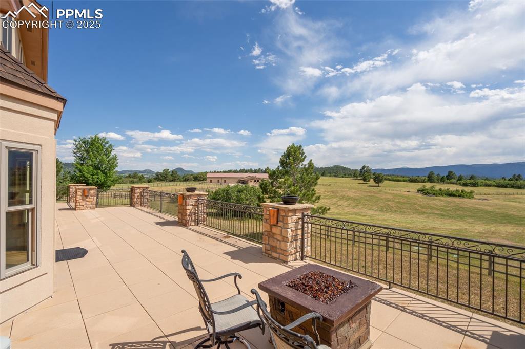 Image 39 of 50: View of patio / terrace featuring an outdoor fire pit, a rural view, and a 