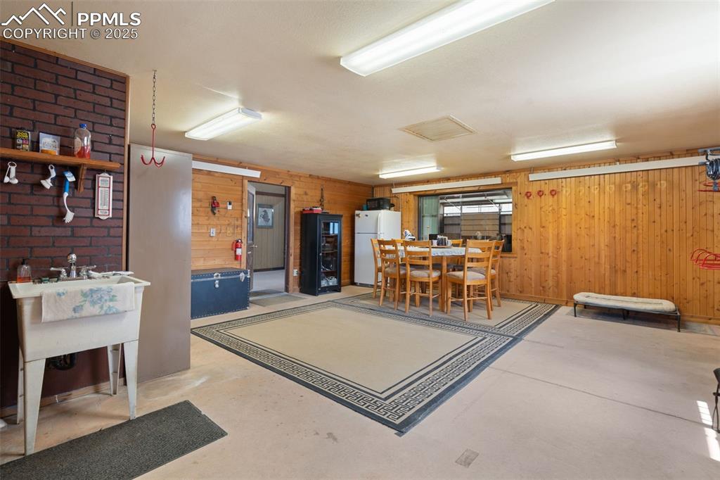 Image 44 of 50: Miscellaneous room with concrete flooring and wood walls
