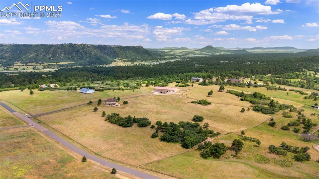 Image 50 of 50: Overview of rural landscape featuring a mountain backdrop and a heavily woo