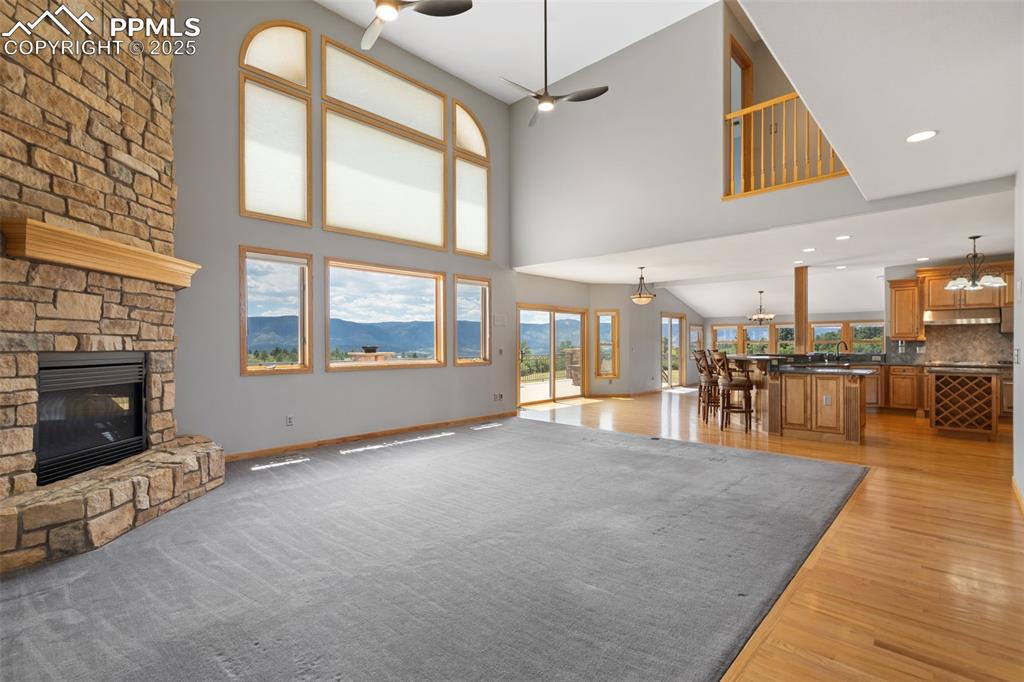 Image 8 of 50: Unfurnished living room with a ceiling fan, a fireplace, light wood finishe