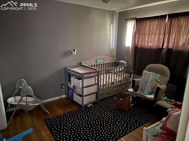 Image 12 of 18: Bedroom with wood finished floors and baseboards