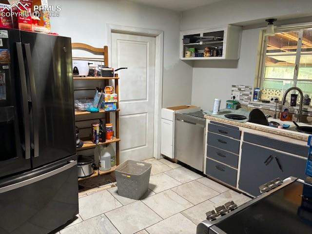 Image 6 of 18: Kitchen featuring freestanding refrigerator, decorative backsplash, dishwas