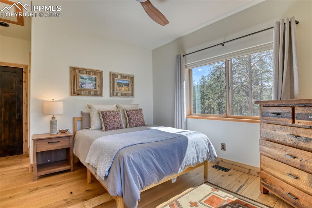 Image 26 of 50: Bedroom #2 on the main level has vaulted ceiling with fan, great windows an