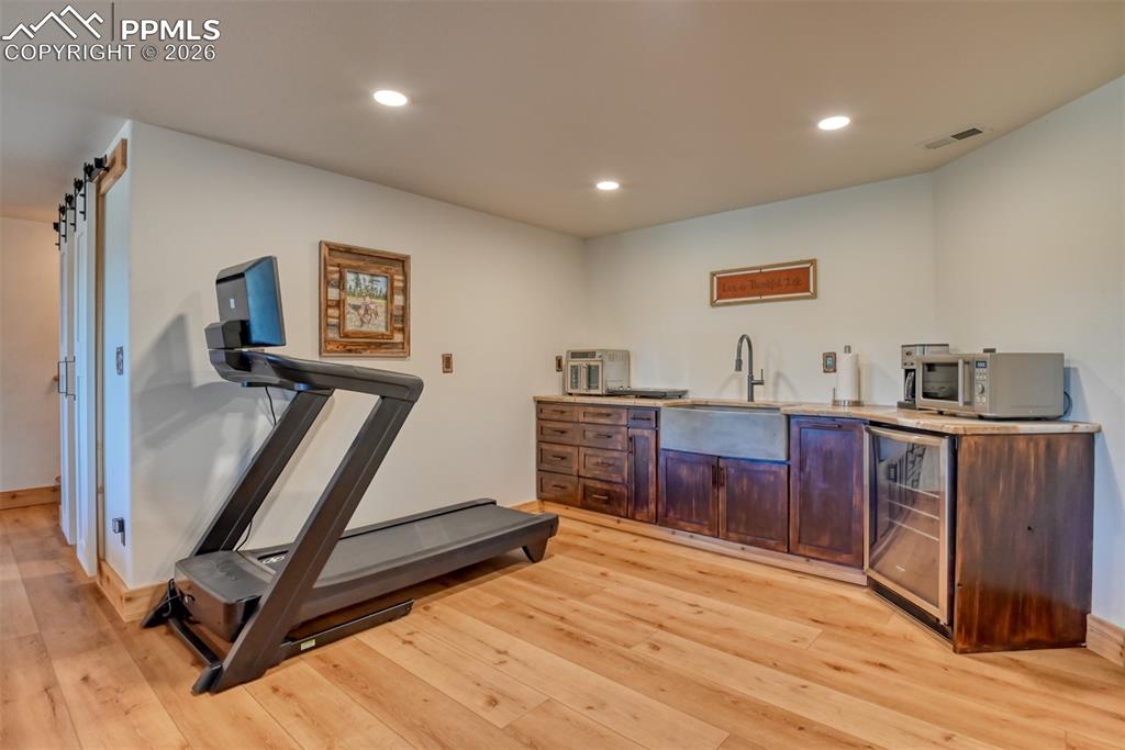 Image 32 of 50: Wet bar sink is a native Trail soapstone sink and beverage refrigerator. 