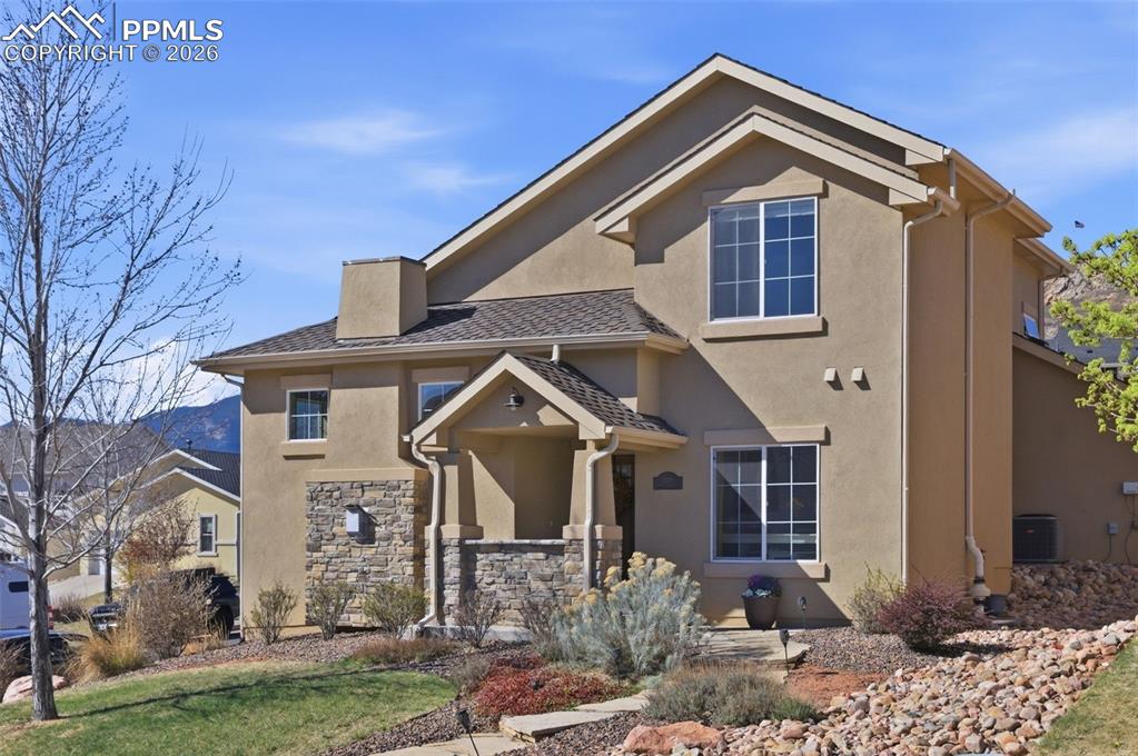 Image 1 of 50: View of front of home featuring stucco siding, a front lawn, and stone sidi