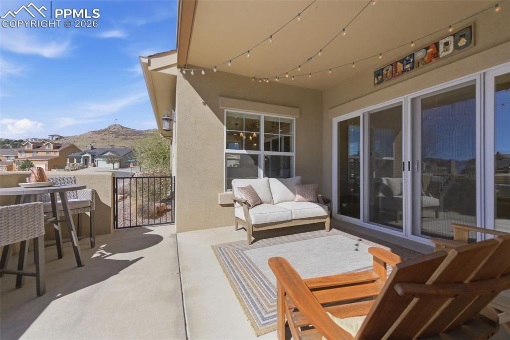 Image 10 of 50: Carpeted living area featuring a stone fireplace and baseboards