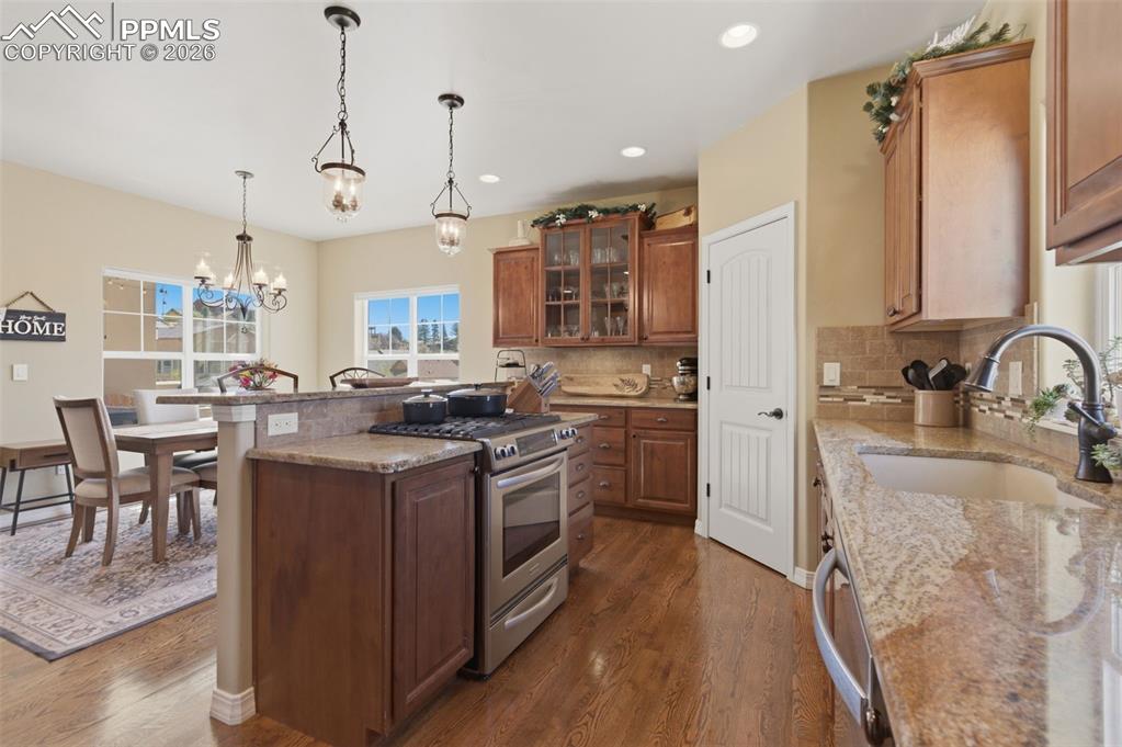 Image 15 of 50: Dining room featuring light wood-style floors and hanging lights