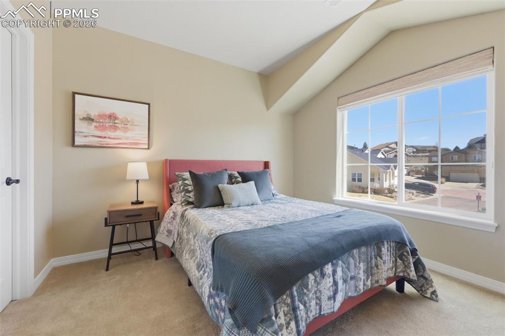 Image 28 of 50: Bedroom with light carpet, connected bathroom, and ceiling fan