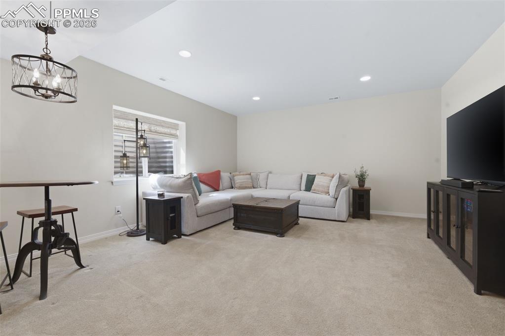 Image 31 of 50: Bedroom with a crib, light colored carpet, lofted ceiling, and recessed lig