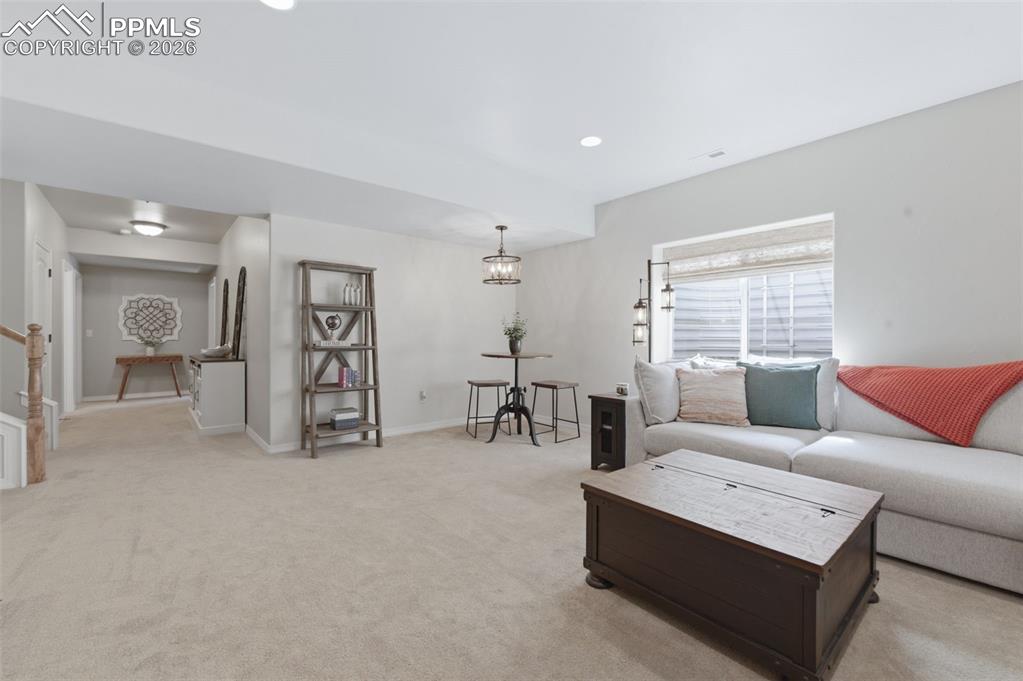 Image 32 of 50: Bedroom with light carpet and vaulted ceiling