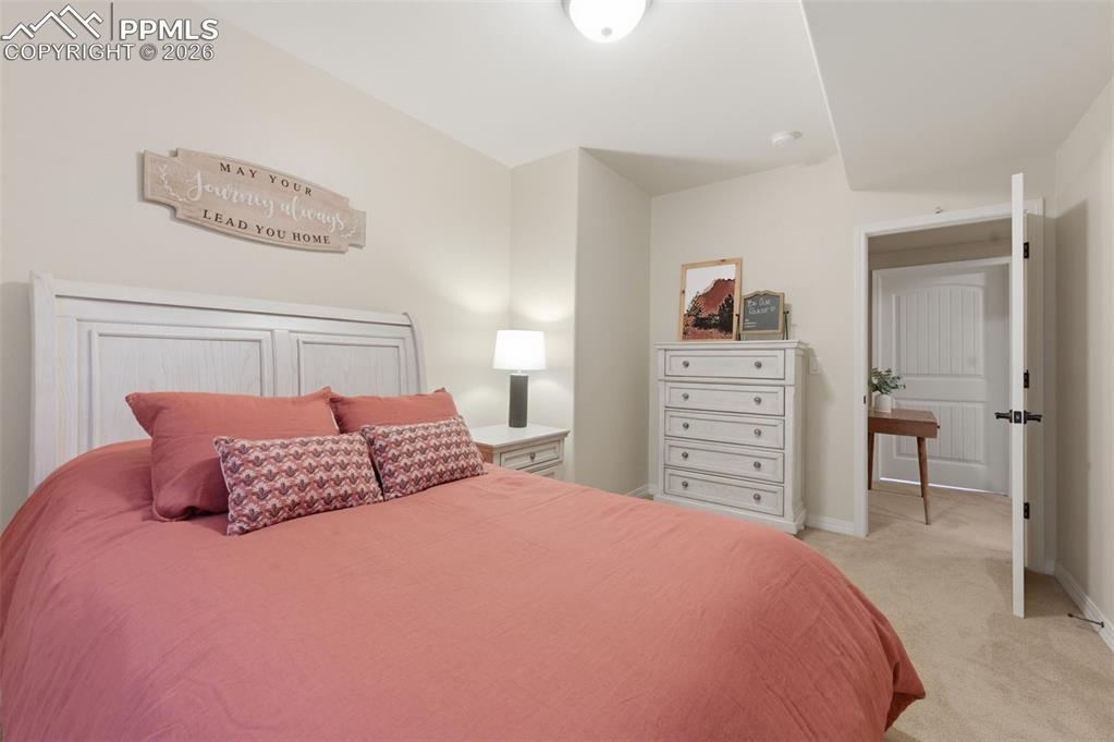 Image 35 of 50: Living area with light carpet and hanging lights