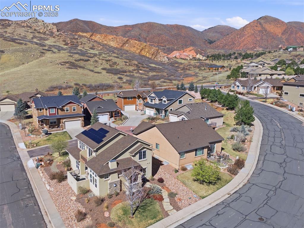 Image 48 of 50: Aerial view of residential area featuring a mountainous background