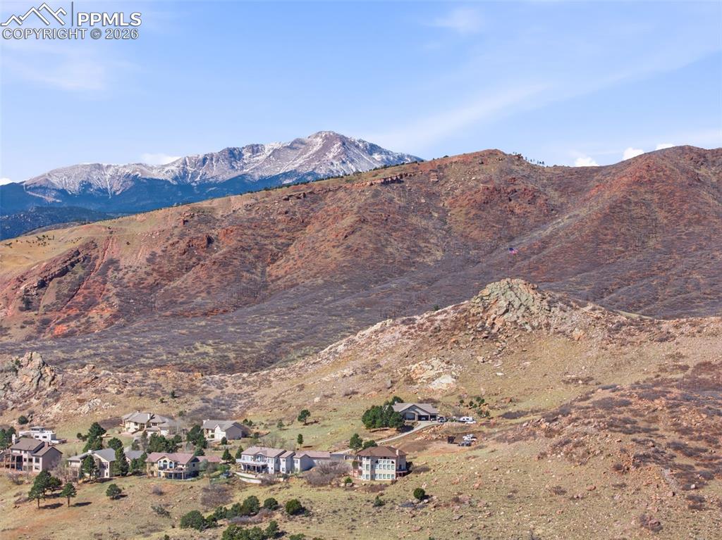 Image 49 of 50: Aerial view of residential area featuring a mountainous background