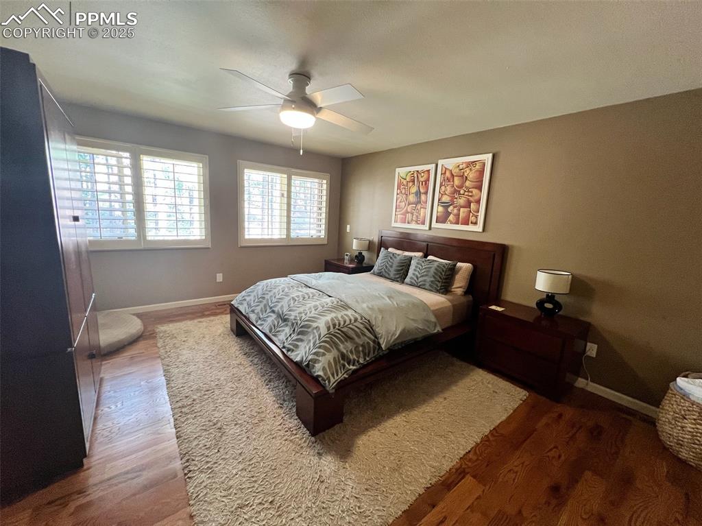 Image 20 of 49: Bedroom with wood finished floors, baseboards, and a ceiling fan