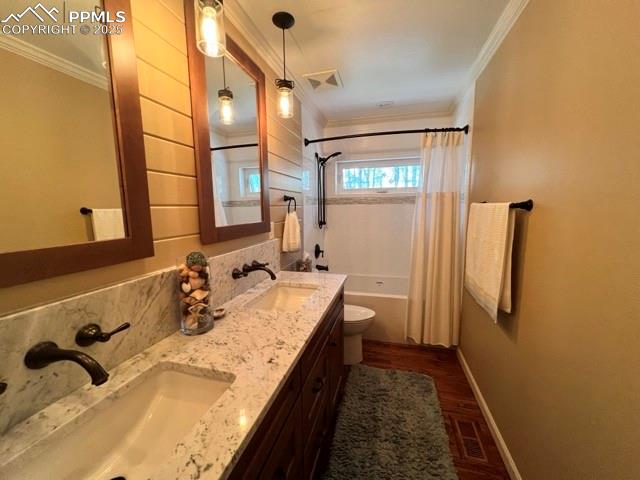 Image 27 of 49: Full bath with crown molding, shower / bath combo, toilet, baseboards, and