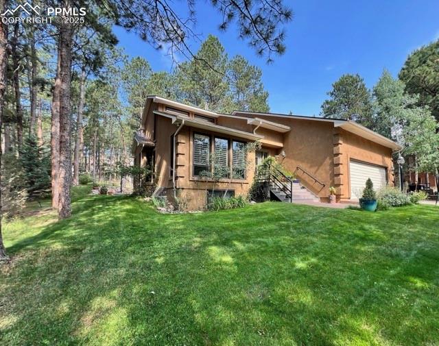 Image 41 of 49: View of front of home with an attached garage and a front lawn