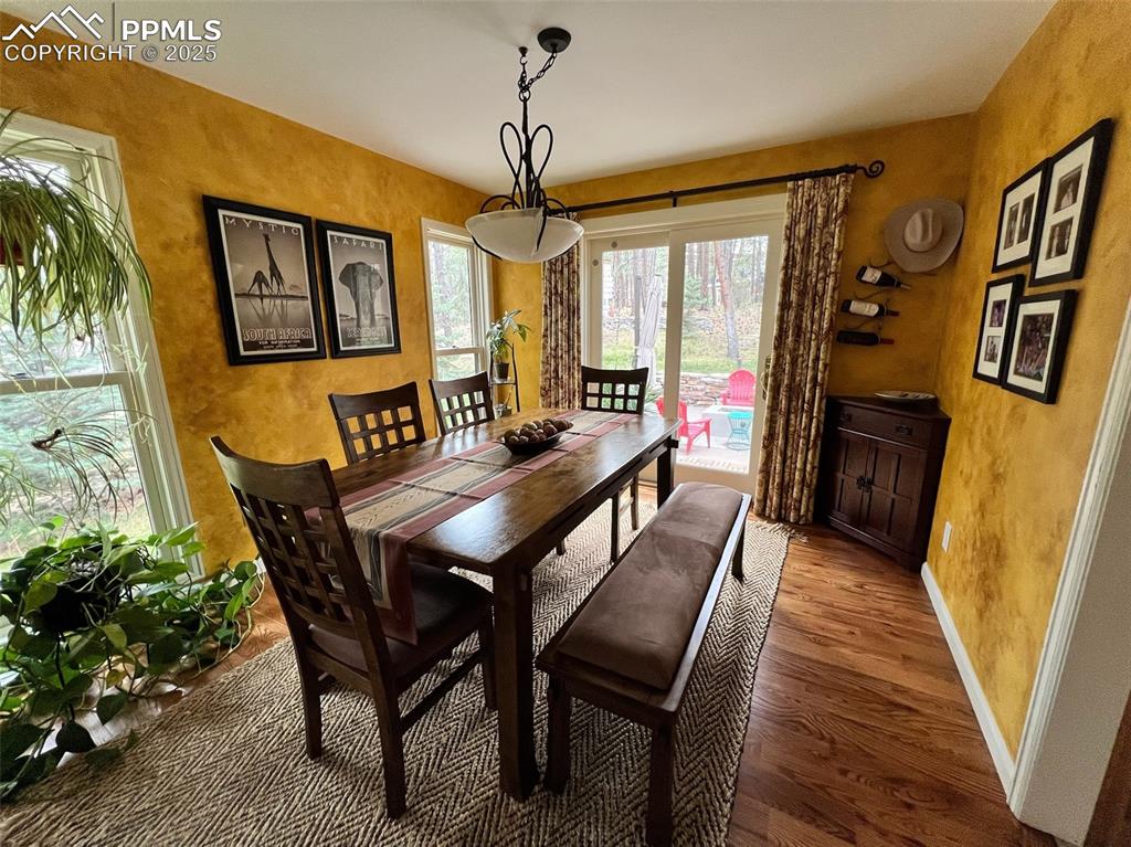 Image 7 of 49: Dining space with wood finished floors, baseboards, and a textured wall
