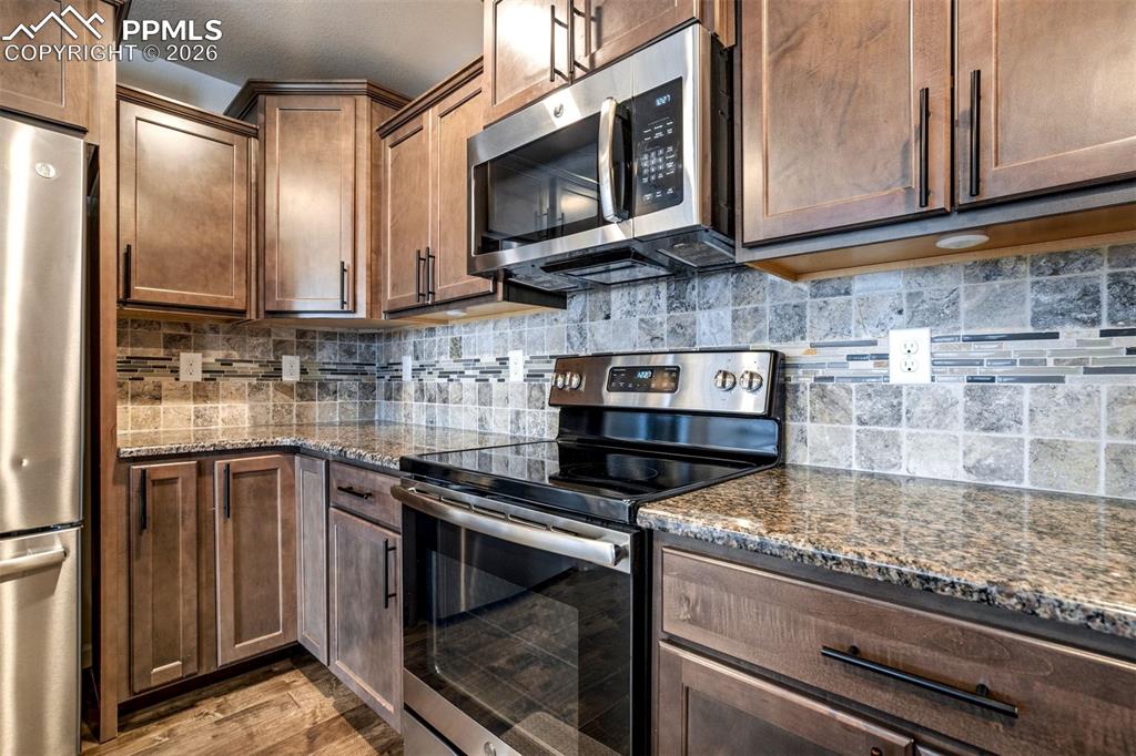 Image 12 of 50: Gourmet Kitchen with Upgraded Appliances, Granite Countertops, Wood Floors,