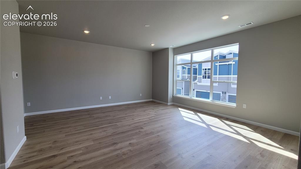 Image 7 of 26: Spacious Living Room with LVP flooring, abundance of natural light, walks o