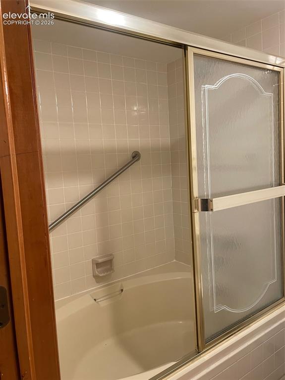 Image 14 of 35: Enclosed soaking tub off main level bedroom.