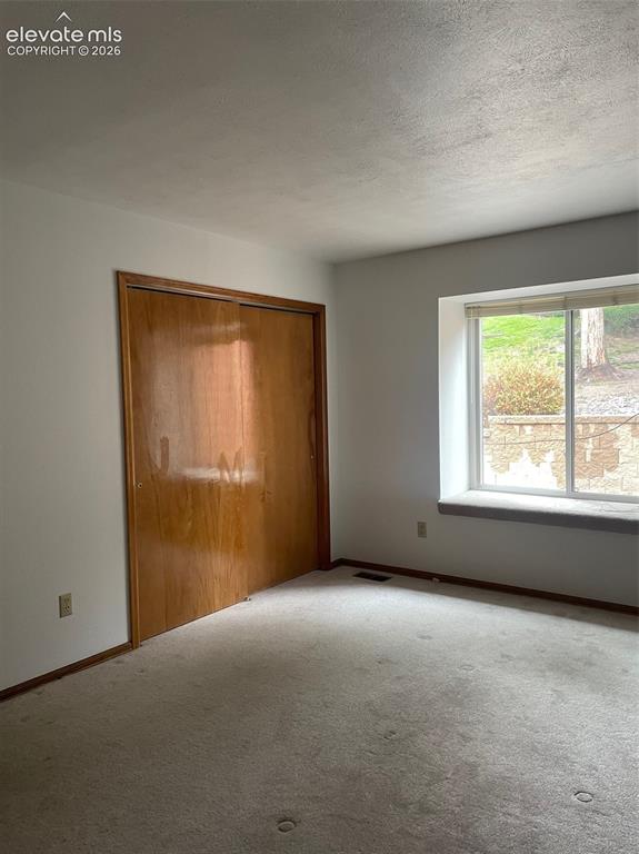 Image 7 of 35: Main level bedroom with views to rear green space.