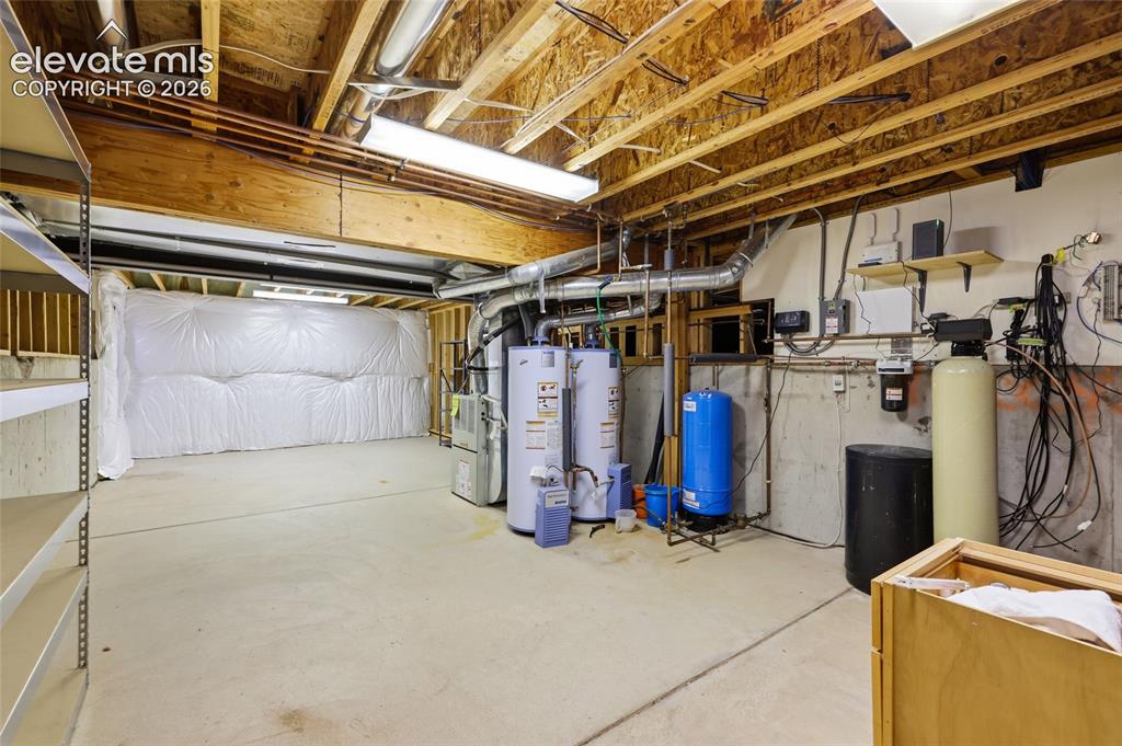 Image 44 of 50: Vaulted ceiling living area featuring hardwood flooring, a stone fireplace 