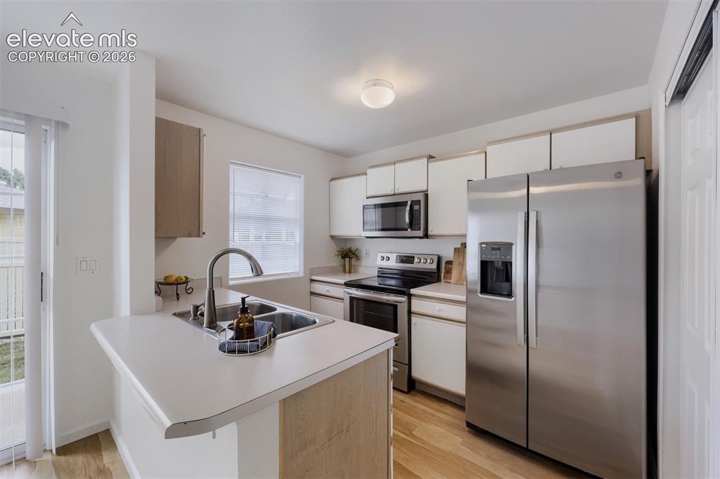 Image 5 of 16: Kitchen with bar and lots of cabinets