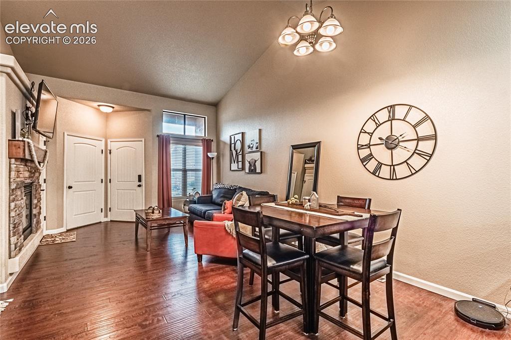 Image 12 of 36: Dining space featuring wood finished floors, a textured wall, a chandelier,