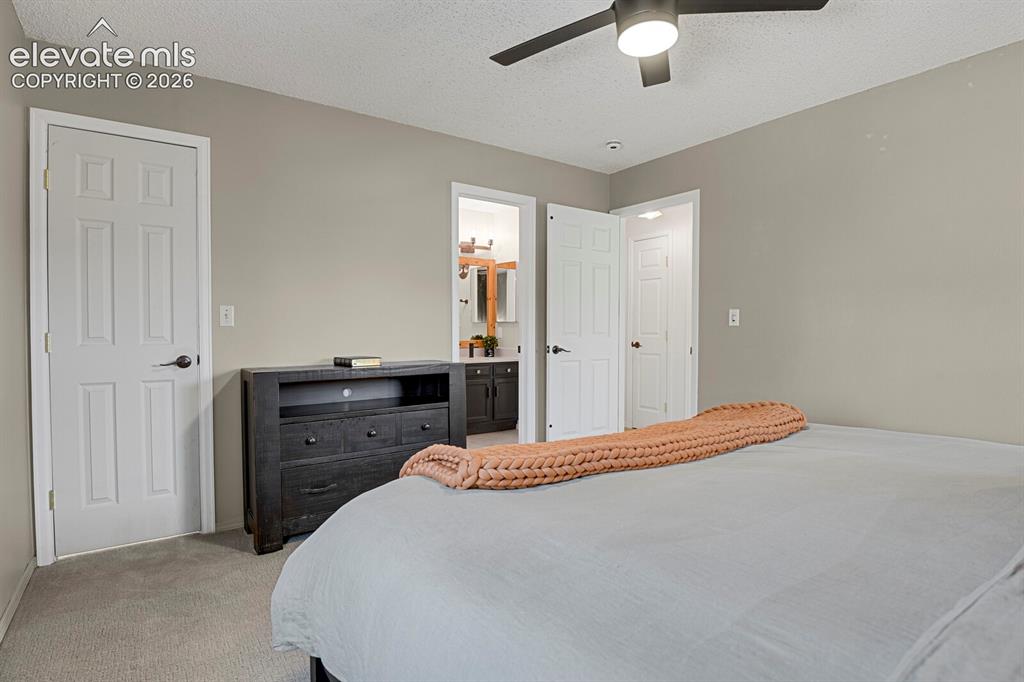 Image 15 of 38: Neutral wall palette with recessed lighting and a ceiling fan