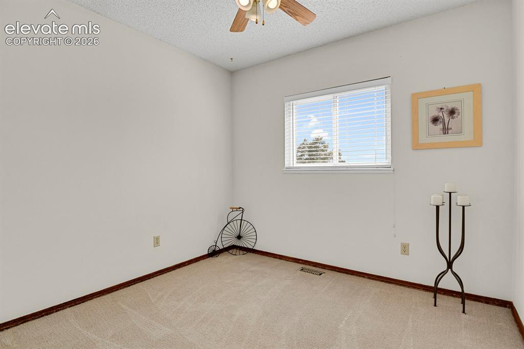 Image 20 of 38: Room featuring neutral-toned carpeting, white walls, a window with blinds, 