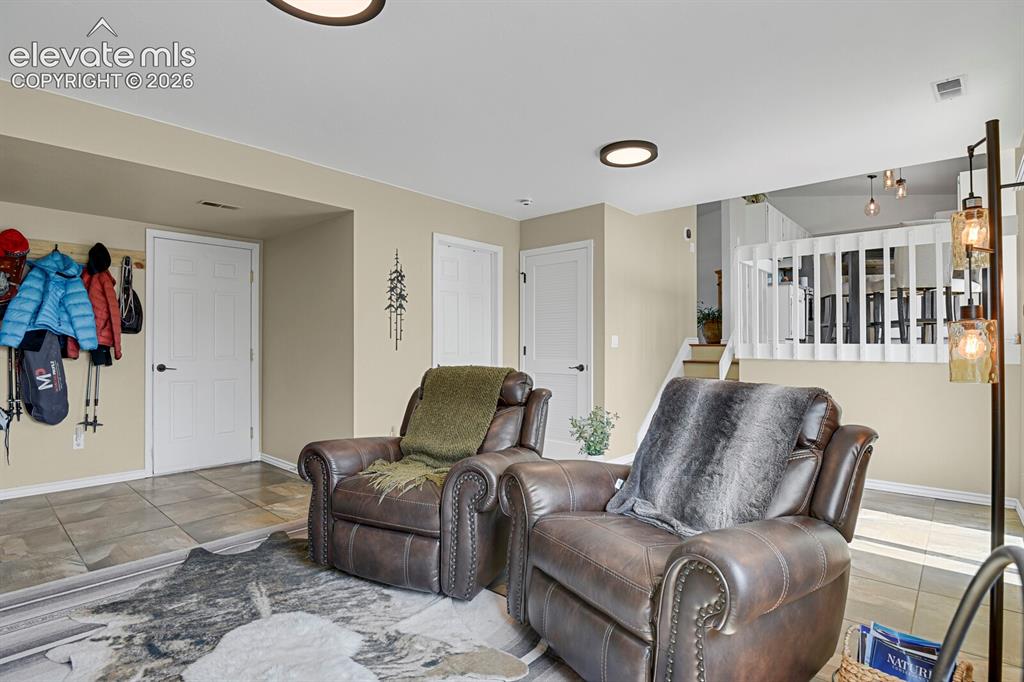 Image 25 of 38: Recessed lighting, light-toned walls, tile flooring, and white interior doo