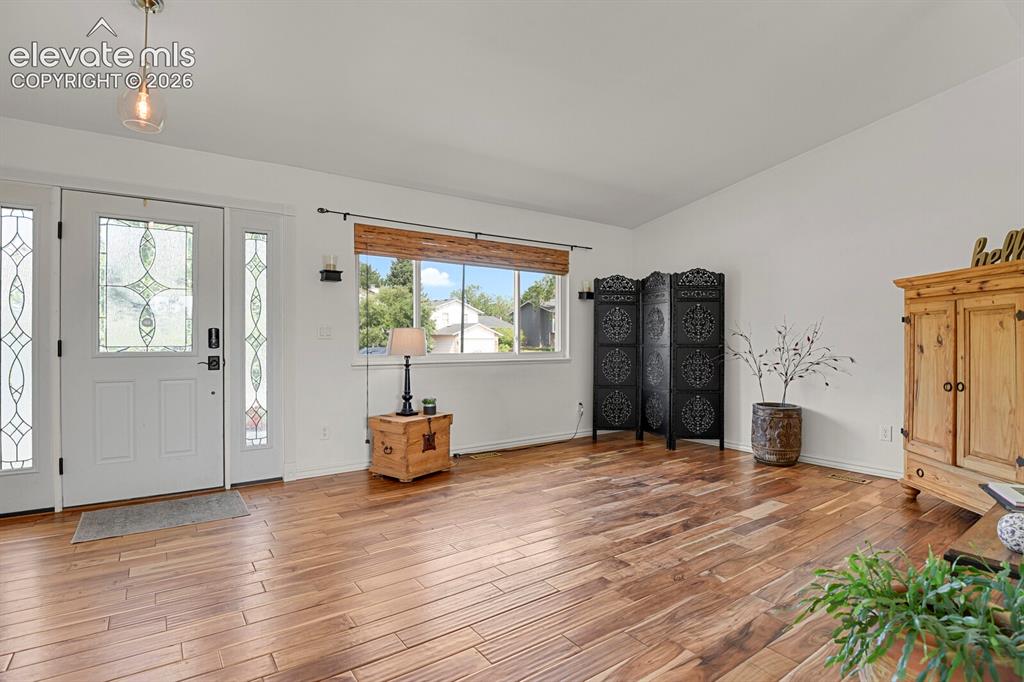 Image 5 of 38: Entryway featuring a decorative glass front door with sidelights, wood-fini