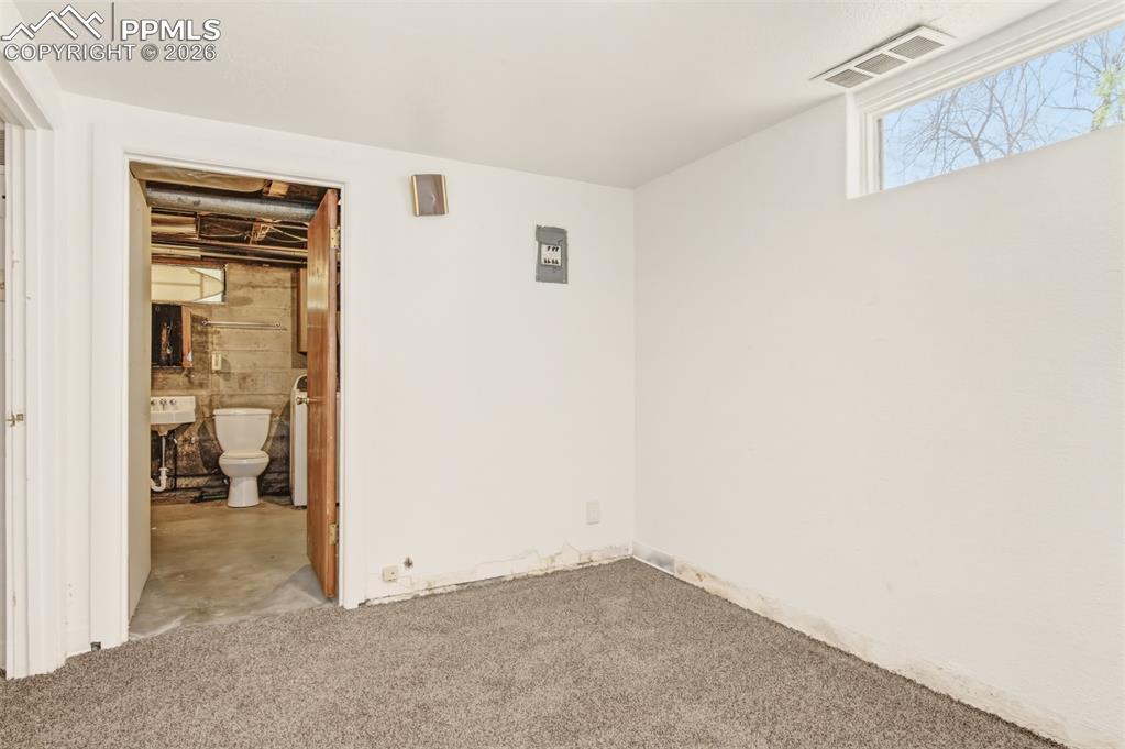 Image 15 of 18: Basement bedroom looking towards bathroom