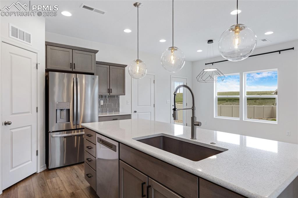 Image 16 of 50: Kitchen featuring stainless steel fridge with ice dispenser, a sink, dishwa