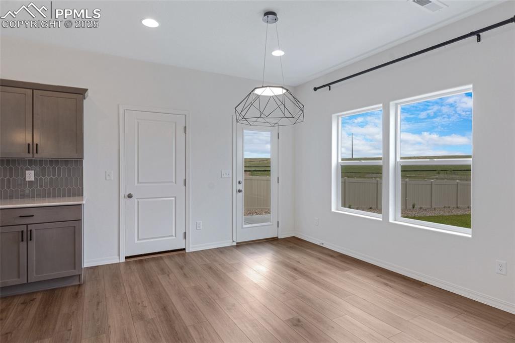 Image 18 of 50: Unfurnished dining area with light wood-style flooring, baseboards, and rec