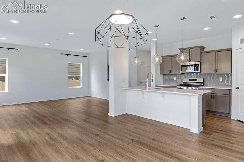Image 19 of 50: Kitchen featuring stainless steel appliances, a sink, decorative backsplash