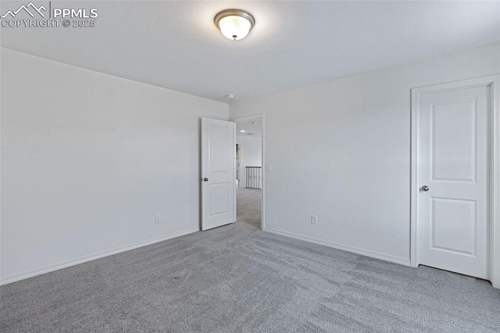 Image 25 of 50: Carpeted empty room with baseboards