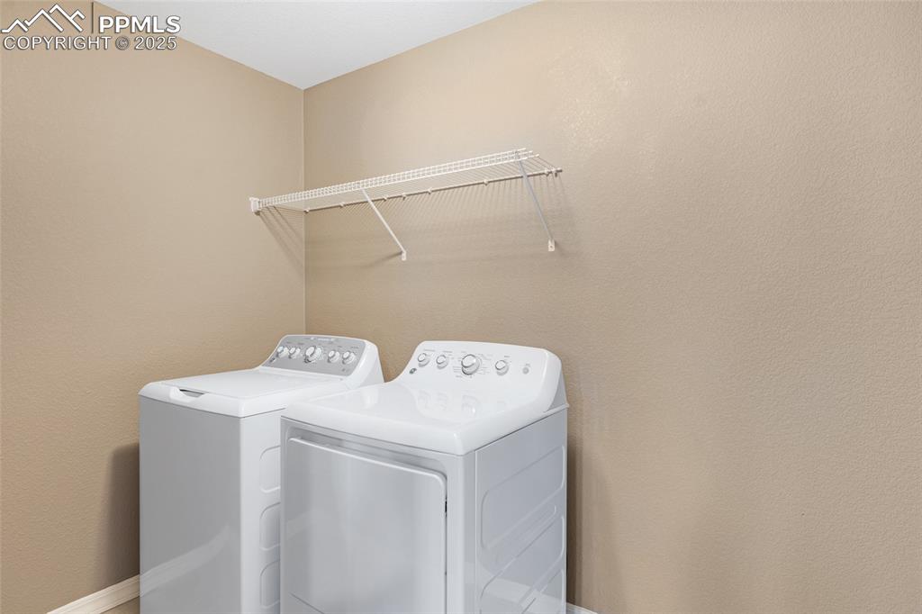 Image 29 of 50: Laundry area featuring washing machine and clothes dryer