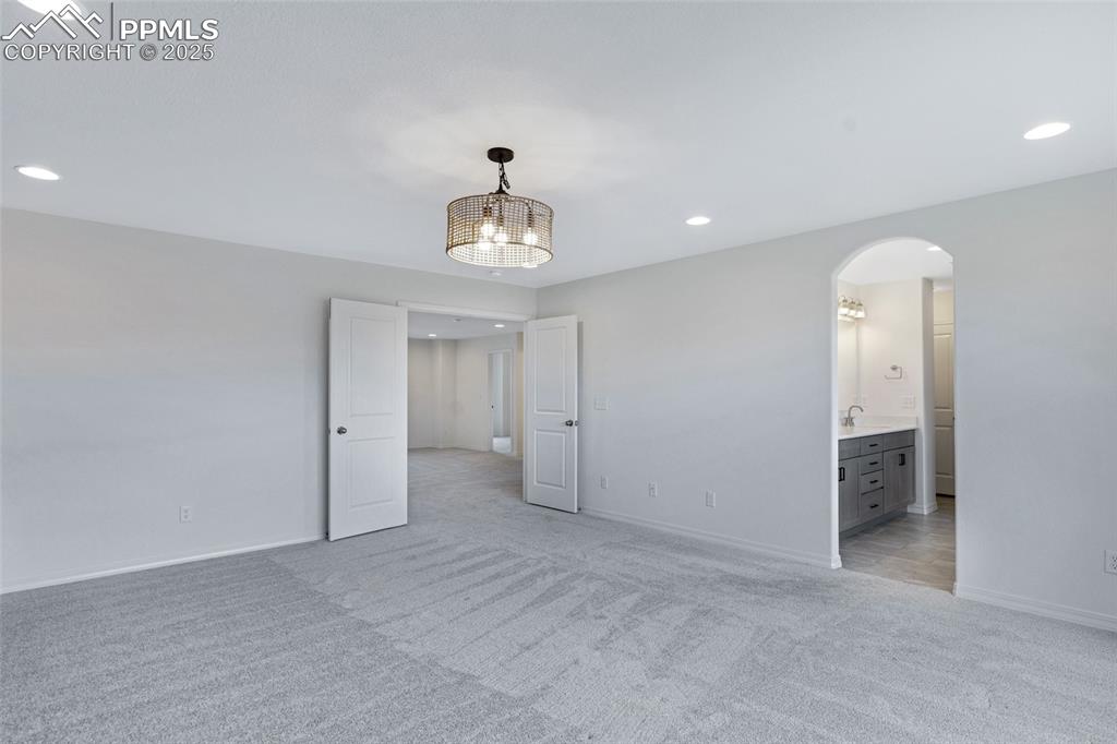Image 31 of 50: Unfurnished room featuring light carpet, recessed lighting, a sink, baseboa