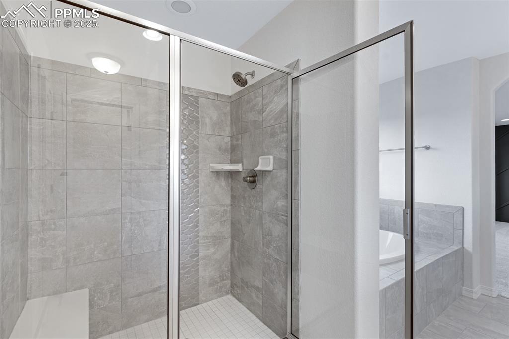 Image 35 of 50: Full bath with a stall shower, a garden tub, and tile patterned floors