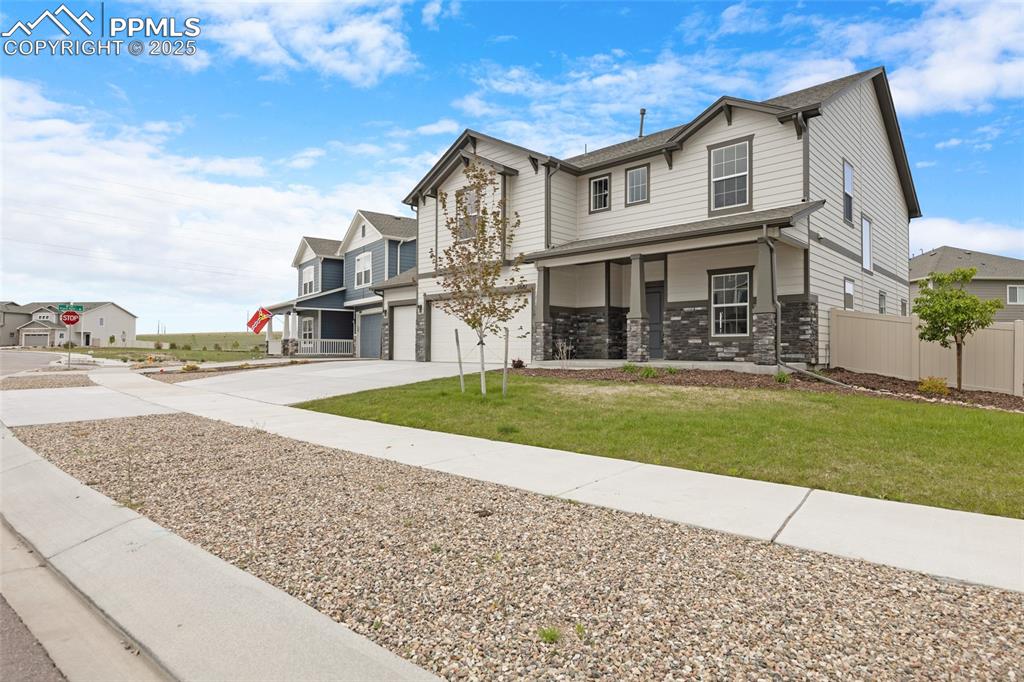 Image 6 of 50: View of front of property featuring an attached garage, driveway, a residen