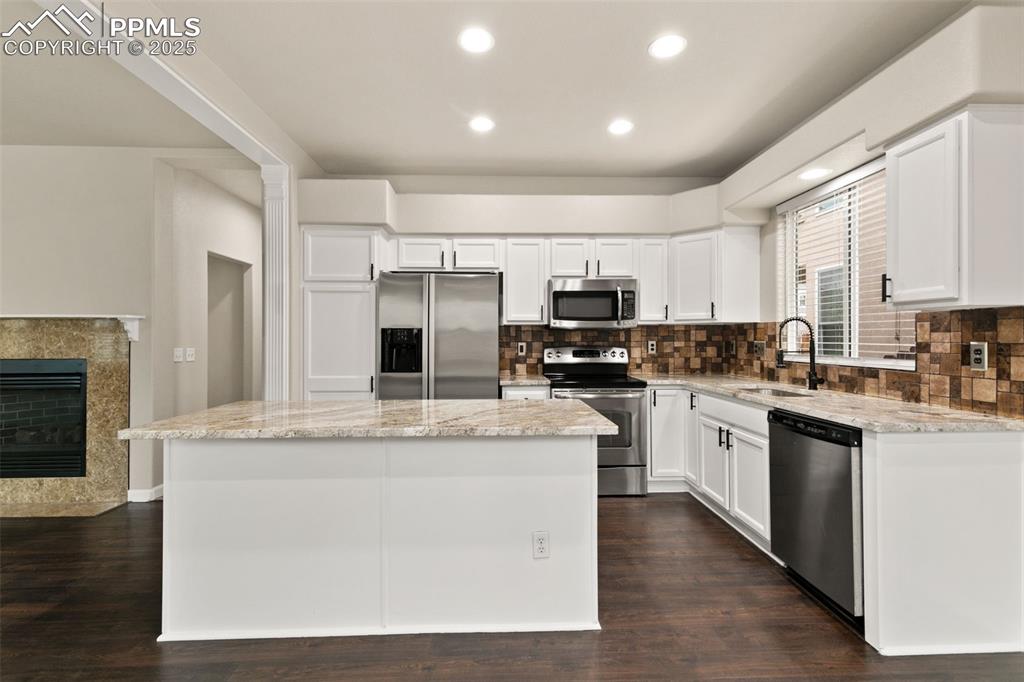 Image 10 of 27: Kitchen with white cabinets, tasteful backsplash, appliances with stainless