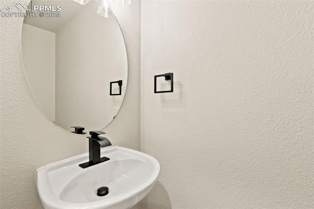 Image 13 of 27: Bathroom with a sink and a textured wall
