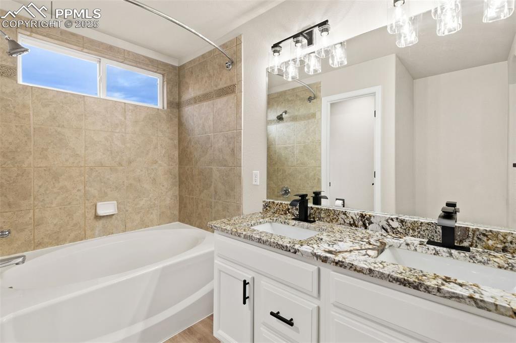Image 17 of 27: Full bathroom featuring shower / tub combination and double vanity